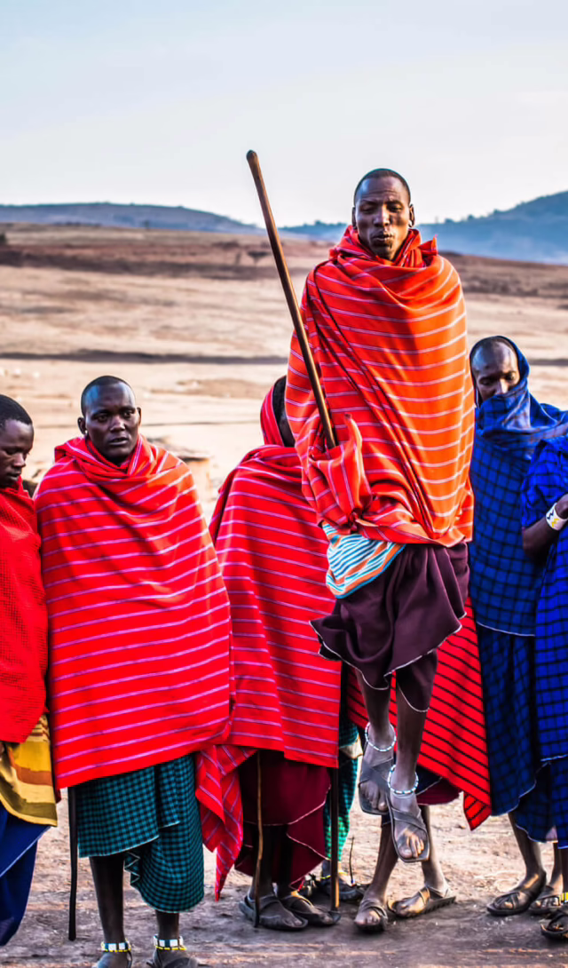 Maasai men performing a traditional jumping dance in the Maasai Mara, Kenya